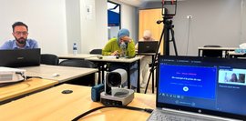 UTC-Personal beim Training zur Erstellung von Social Media Videos Drei Personen sitzen in einem Lehrsaal und beugen sich über ihre Notizen.