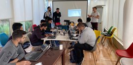 Ein Trainer erklärt PLC-Programmierung vor einer Gruppe Teilnehmender. Die Schulung findet in einem modern ausgestatteten Seminarraum statt.