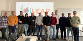 Die beteiligten Projektpartner stehen in einem Seminarraum vor den iLEAP Logo für ein Gruppenfoto.  