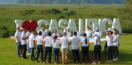Das Bild zeigt eine Gruppe von jungen Menschen in der Natur, die an einem Teambuilding-Workshop teilnehmen.