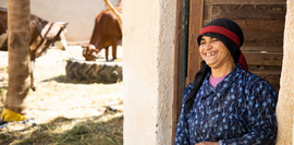 Das Bild zeigt eine Bäuerin mit Rindern im Innenhof.