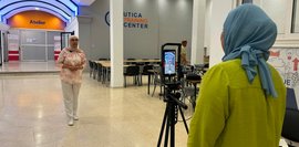 UTC-Personal bei einer praktischen Übung im Rahmen des Trainings zur Erstellung von Social Media Videos Eine junge Frau mit Kopftuch steht vor einer Handykamera und wird von ihrer Kollegin gefilmt.