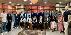 Gruppenfoto von ca. 25 Personen, größtenteils Männer und Frauen in Businesskleidung, bei einem Workshop zu Herausforderungen für KMU. Der Raum ist elegant eingerichtet mit Teppich und Kronleuchter.