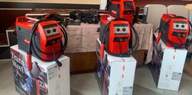 Mehrere moderne Schweißgeräte stehen in einem Schulungsraum, noch in der Verpackung und bereit für den Einsatz.