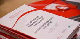 Eine weiße Mappe mit roten Elementen zeigt den Titel der Berufsbildungspartnerschaft in der Ukraine in deutscher und ukrainischer Sprache.
