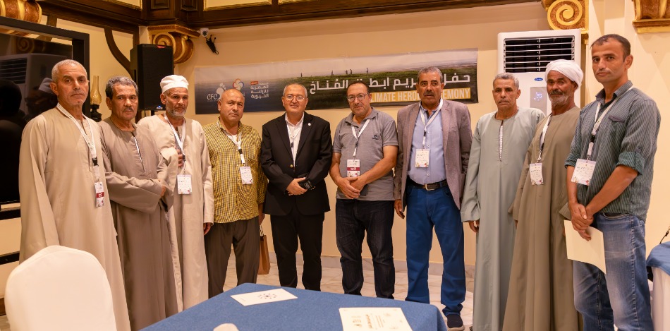 Das Bild zeigt 6 Bauern bei der Übergabe von Economy of Love - CO2 Zertifikaten gemeinsam mit  weiteren Personen.