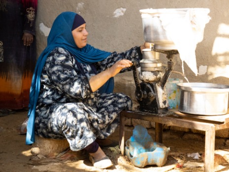 Das Bild zeigt eine Bäuerin bei der Herstellung von Quark