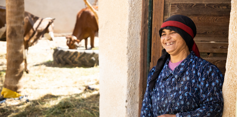 Das Bild zeigt eine Bäuerin mit Rindern im Innenhof.