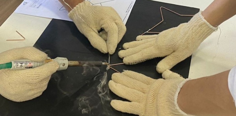 Das Bild zeigt zwei Teilnehmer beim Löten.