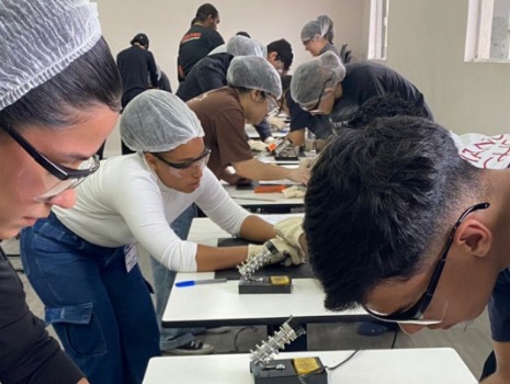 Das Bild zeigt eine Gruppe Jugendlicher die Sterne aus Draht zusammenlöten