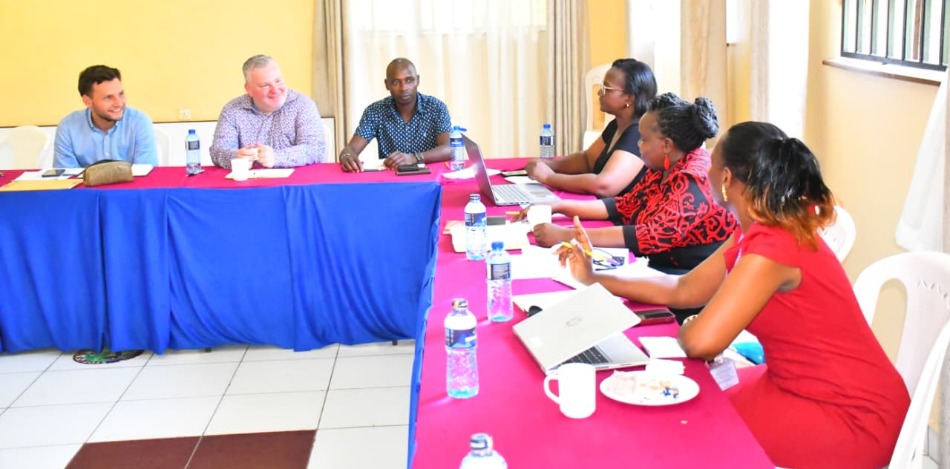 Mehrere Teilnehmende sitzen während einer Projektbesprechung in Kenia an Tischen zusammen. Das Bild zeigt den Austausch zwischen Vertreterinnen und Vertretern der bbw gGmbH und kenianischen Partnern im Rahmen der Projektplanung und Zusammenarbeit.