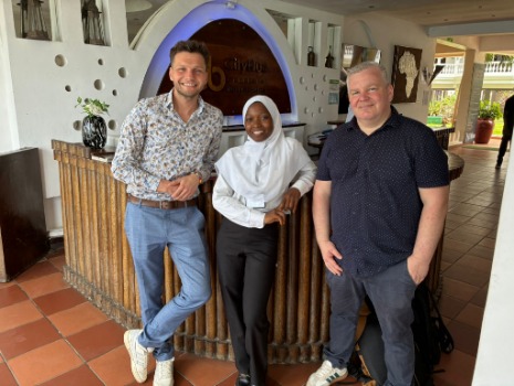 Vertreter der bbw gGmbH und eine lokale Partnerin aus dem Hospitality-Bereich stehen gemeinsam in einem Hotel-Empfangsbereich in Kenia. Das Bild steht für Kooperation, praxisnahen Austausch und die Verbindung zwischen beruflicher Ausbildung und Beschäftigungsperspektiven.