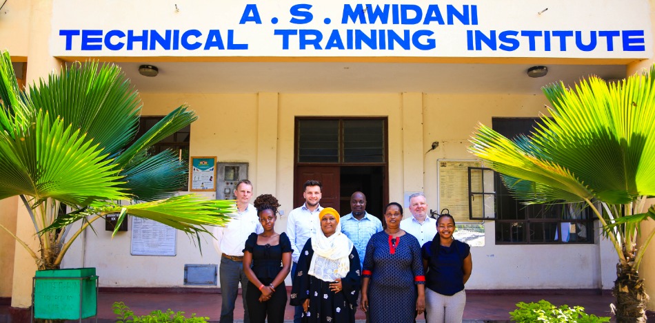 Neun Personen stehen für ein Gruppenfoto vor dem Eingang eines technischen Ausbildungsinstituts in Kenia.