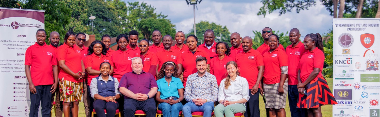 Das Bild zeigt eine Gruppe von Teilnehmenden eines Workshops zur Stärkung der Zusammenarbeit zwischen TVET-Zentren und der Industrie, posierend vor Bannern mit der Aufschrift „Strengthening TVET and Industry Partnerships“