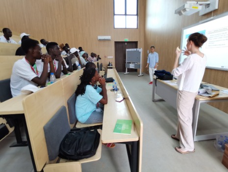 In einem Amphitheater sitzen die senegalesischen Studierenden und 2 Personen erklären etwas. 